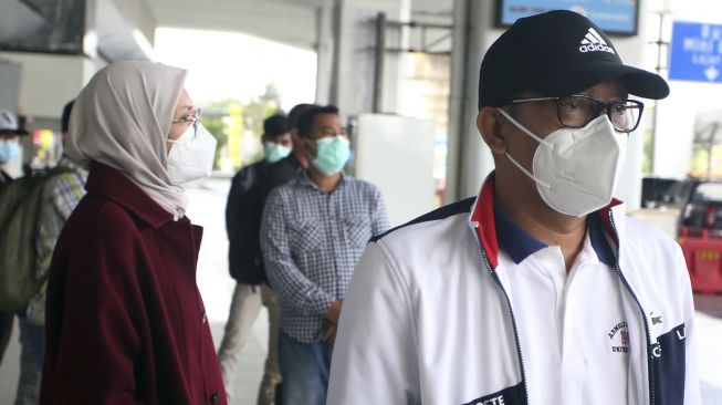 Bupati Probolinggo Puput Tantriana Sari (kiri) dan suaminya yang juga anggota DPR dari Partai NasDem Hasan Aminudin (kanan) berjalan keluar dari Terminal 3 setibanya di Bandara Soekarno Hatta, Tangerang, Banten, Senin (30/8/2021). [ANTARA FOTO/Muhammad Iqbal]